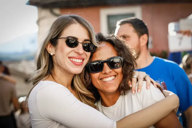Due amiche abbracciate e sorridenti durante la sagra
