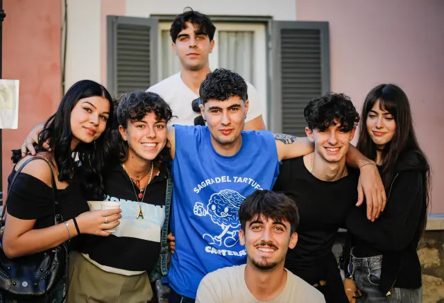 Gruppo di amici abbracciati, uno con la maglietta ufficiale della Sagra del Tartufo