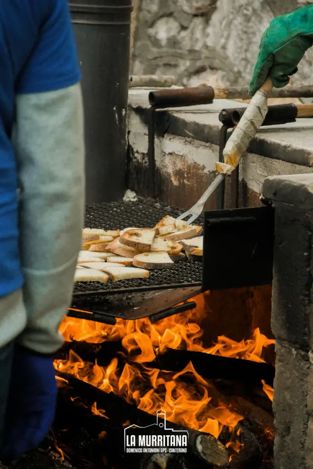 Fette di pane sulla griglia a fuoco vivo per la preparazione delle bruschette
