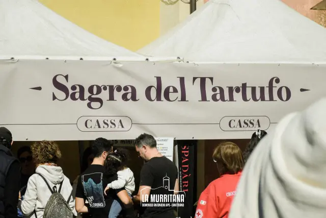 Gazebo con insegna "Sagra del Tartufo" e banco cassa, visitatori in fila