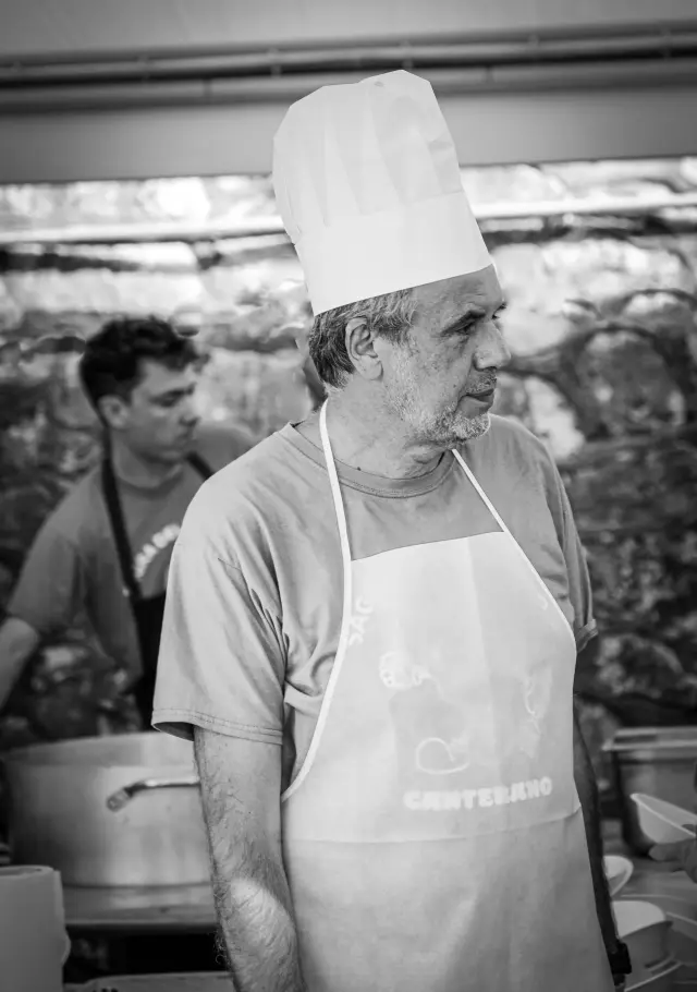 Ritratto in bianco e nero di un cuoco con cappello da chef durante la preparazione