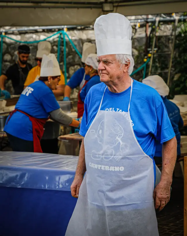 Volontario con cappello da cuoco e grembiule "Canterano" nella cucina della sagra