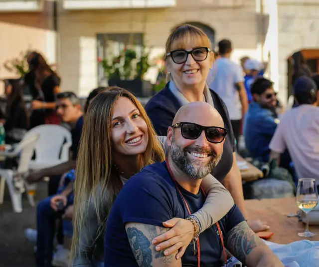 Famiglia sorridente seduta al tavolo durante il pranzo della sagra