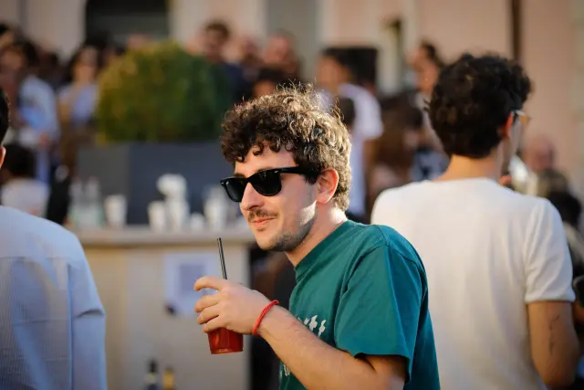 Giovane visitatore sorridente con un drink alla frutta in mano