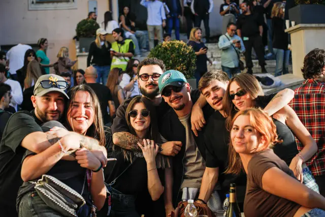 Gruppo di amici in posa nella piazza durante la sagra, luce calda della sera