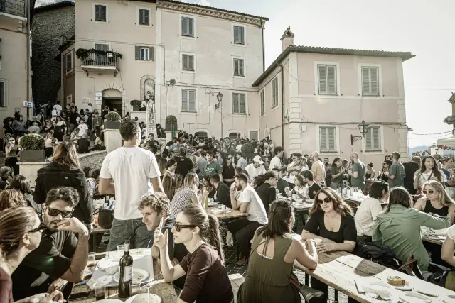 Piazza con tavolate affollate di visitatori durante il pranzo della sagra