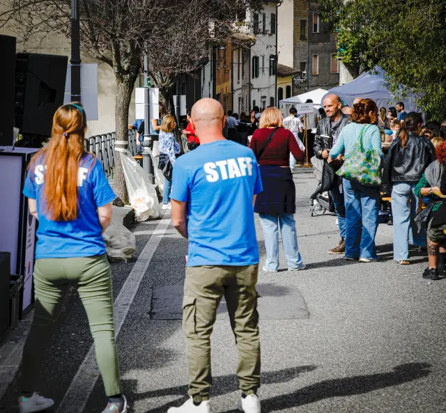 Due membri dello staff che camminano lungo la via principale del paese