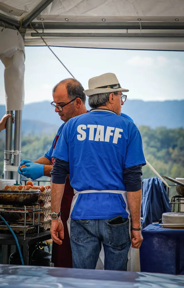 Due membri dello staff che preparano le uova nella cucina della sagra