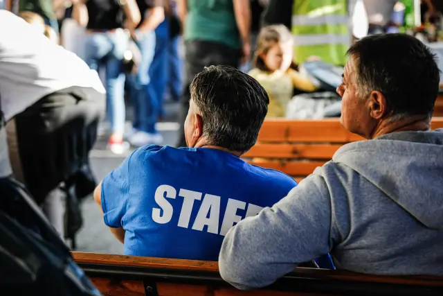 Due membri dello staff seduti di spalle su una panchina durante un momento di pausa